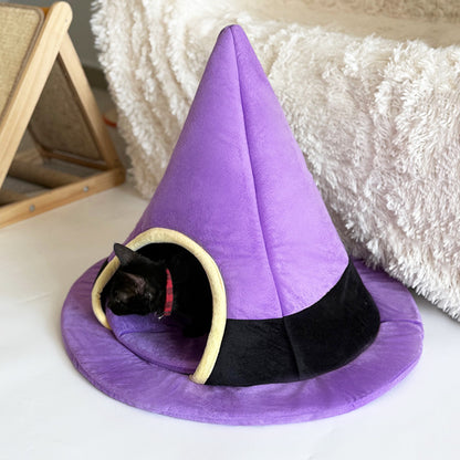 Gato asomado dentro de la cueva con forma de sombrero de bruja