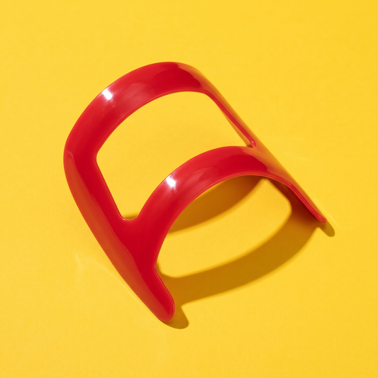 Plantilla roja de plástico para perfilar la perilla, sobre fondo amarillo