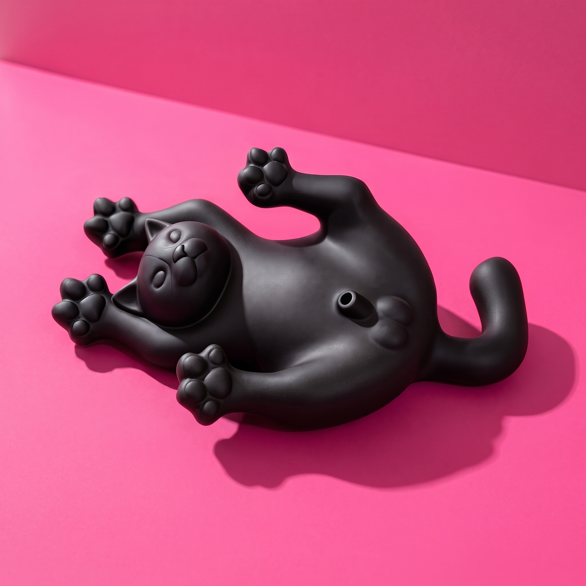Figura de gato negro tumbado panza arriba para incienso, sobre fondo rosa